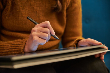 Closeup of a person writing on a tablet. Close up of a person working on a tablet. Woman working on a convertible.