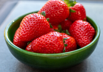 Red ripe strawberries in green bowl