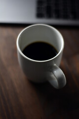 Cup of coffee and notebook on a wooden office table