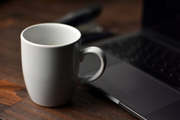 Cup of coffee and notebook on a wooden office table