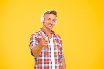 Feel the rhythm. Happy man listen to music pointing index finger. Music technology. Modern technology. Fun and entertainment. Listening to it the way you should