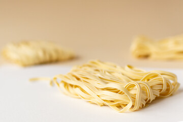 Natural dry homemade noodles on a brown background. Horizontal orientation. Copy space. Selective focus.