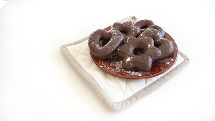 Homemade gingerbread covered with chocolate on brown ceramic plate on white background 