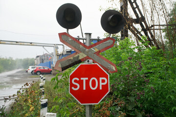 Stop traffic sign and semaphore next to the old railway crossing. Against the backdrop of a...