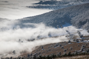 amazing winter landscape with fog and frosty trees in  Romania
