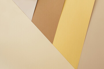Earthy brown, gold, beige, white paper geometric background. Minimal, stylish, trend concept. Flat lay, top view, copy space. Trend color 2021