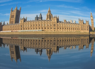 Houses of Parliament reflected in river Thames in London with fi