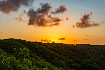 Pôr o sol com céu amarelo e montanhas ao fundo