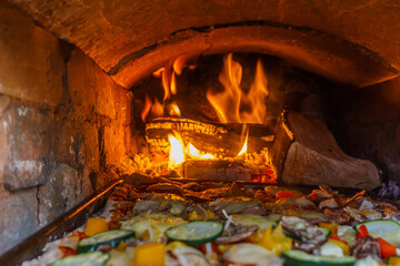 Pizza baking in an open handmade firewood oven