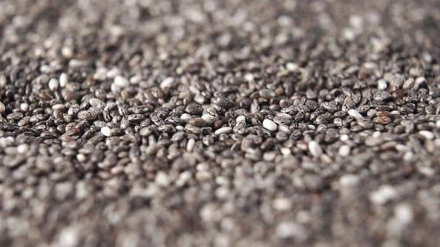 Falling chia seeds close-up with rotation. Macro shot. Slow motion