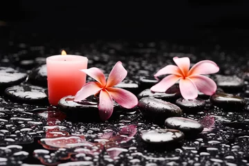 Fototapete spa still life of with two pink frangipani with pink candle  and zen black stones ,wet background  © Mee Ting