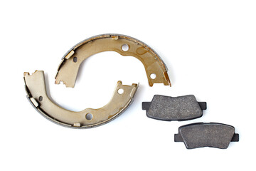 set of asbestos brake pads and brake shoe for disc and drum brakes, replacement spare parts of the car brake system isolated on white background top view, nobody.