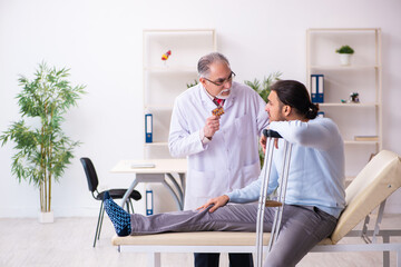 Obraz premium Young leg injured man visiting old doctor osteopath