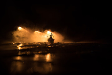 Silhouettes of a crowd standing at blurred military war ship on foggy background. Selective focus....