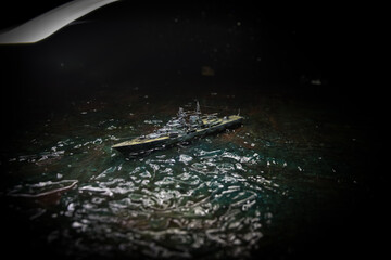 Silhouettes of a crowd standing at blurred military war ship on foggy background. Selective focus. Passengers try to escape. Protest of people