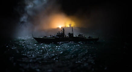 Silhouettes of a crowd standing at blurred military war ship on foggy background. Selective focus....