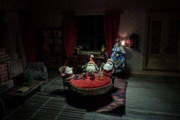 A realistic dollhouse living room with furniture and window at night. Artwork table decoration with handmade realistic dollhouse. Selective focus.