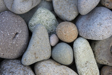 Fototapeta na wymiar 色々な色と大きさの、丸みを帯びたたくさんの石