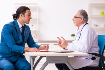 Young businessman meeting with old doctor