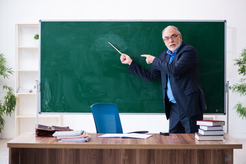 Old male math teacher in the classroom