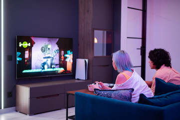 Photo of young couple playing video games at home at night - 397708542