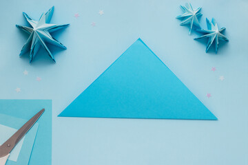 Simple origami 3D Christmas tree made from blue paper. Step by step instruction, step 2. Take the...