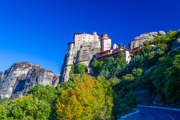 Obraz premium Greece. Thessaly. Kalambaka. The Rusanu Monastery. The monastery complex is located on the rocks. A stone temple on top of a cliff. Meteora Monasteries in Greece. Thessaly in sunny weather