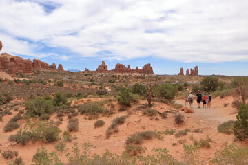 Fototapeta na wymiar Hikers viewing the sandstone formations in the desert, Arches National Park