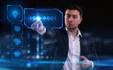 Business, Technology, Internet and network concept. Young businessman working on a virtual screen of the future and sees the inscription: ISO 9001