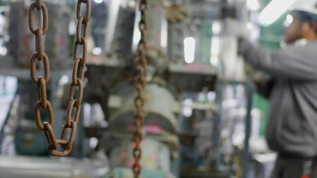 Mechanics are servicing the machines in the factory to prepare for the next production run.