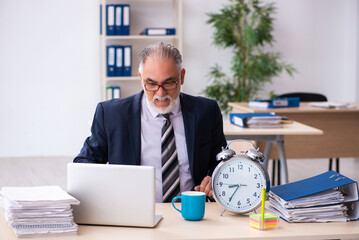 Old businessman drinking coffee in time management concept