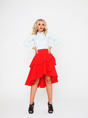 Blond fashion model with luxury hair and red skirt in studio over white background