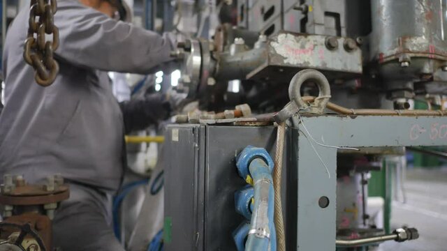 Mechanics are servicing the machines in the factory to prepare for the next production run.