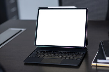 Digital tablet with blank screen on black table in office. Mock up.