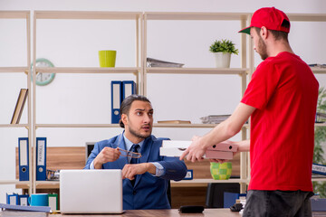 Fototapeta premium Young man delivering pizza to the office