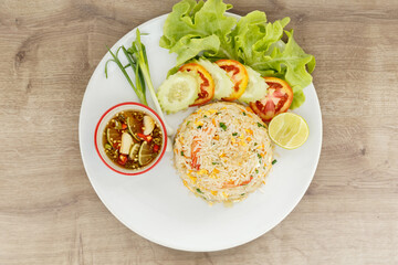Top view fried rice with seafood on wooden table.