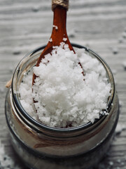 유리용기에 담긴 바다소금과 나무 숟가락 
