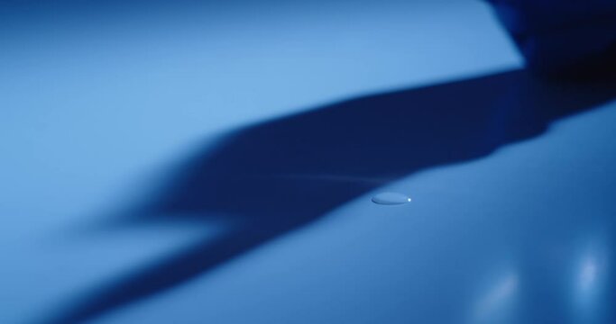 Drops Of Liquid Landing On Table In High-Contrast Light