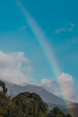 Tasmanian landscape with green hills and mountains with rainbow
