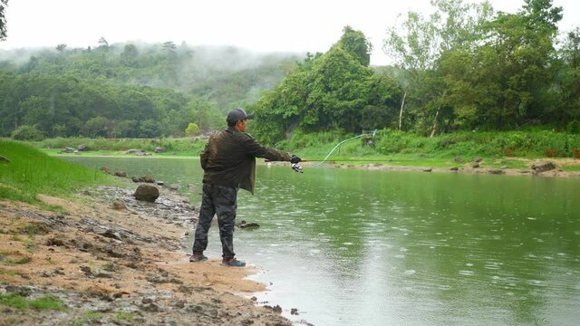 A man fishing in a large lagoon, weekend leisure activity.