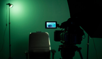 Green screen background and a black chair in a television Studio.