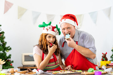 Happy family. Father and daughter wearing kitchen apron decorating Xmas cookies in the kitchen with Christmas tree at home. Cooking and Holiday concept. Merry Christmas and Happy New Year