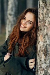 Fototapeta premium Smiling woman in warm jacket in the forest vacation lifestyle