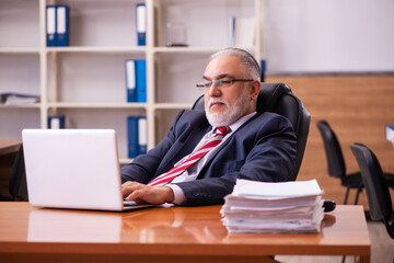 Old male employee sitting in the office