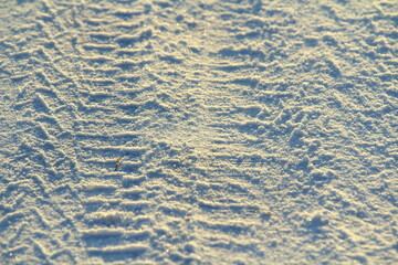 Tire tracks left in the snow on a bright sunny day