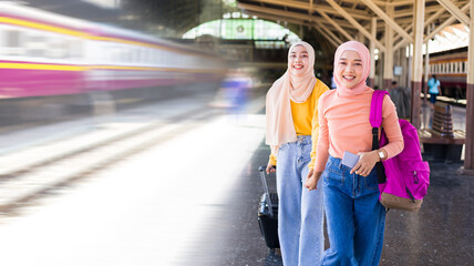 Two Muslim women were running to get on the train on the platform.