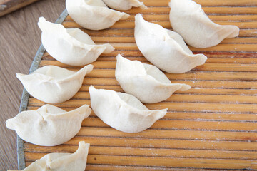 Looking down on a round plate with wrapped white flour dumplings
