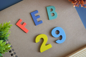 February 29, Cover design in natural concept with a brown notebook and colorful wooden alphabet.