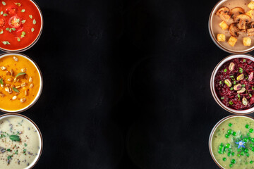 Vegan soup banner with copy space. Vegetable cream soups, shot from the top, a flat lay on a black background