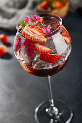 Cocktail garnished with strawberry and flower petal